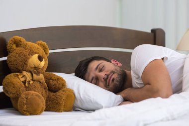 Yumuşak oyuncağın yanında uyuyan adam