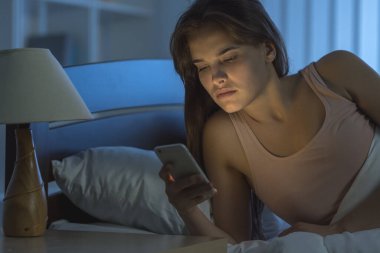 Yatak odasındaki uykulu kadın telefonu. Gece vakti.
