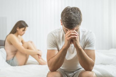 İktidarsız adam yatakta kadının yanına oturur.