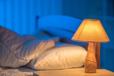 Yatağın arka planındaki lamba. Gece vakti.