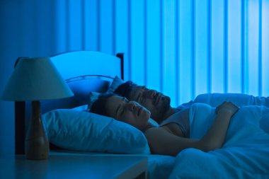 Kadın ve erkek rahat bir yatakta uyuyorlar. Gece vakti, tüm dikkatini topla.