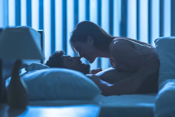 The young couple kissing in the bed. night time
