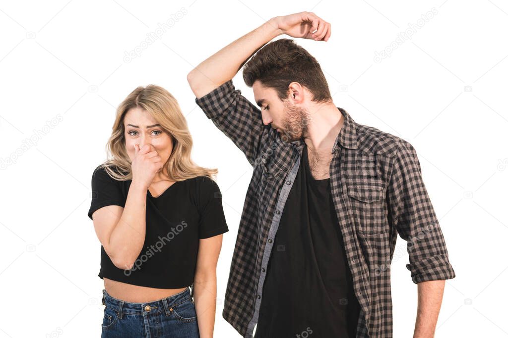 The man smells armpits near the woman on the white background