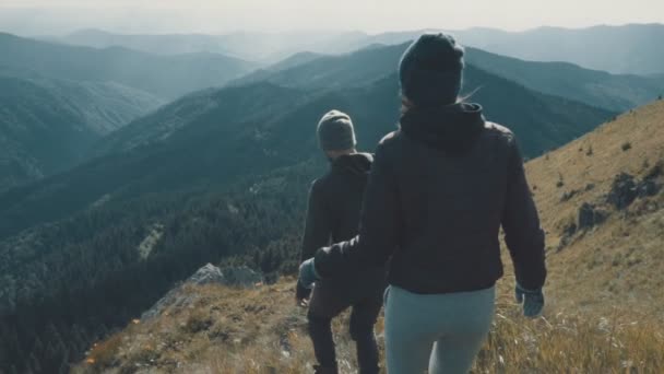 男と女が岩の上を歩いている スローモーション — ストック動画