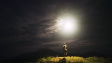Adamın üzerinde parlak bir ışık uçuşuyla uçan UFO.