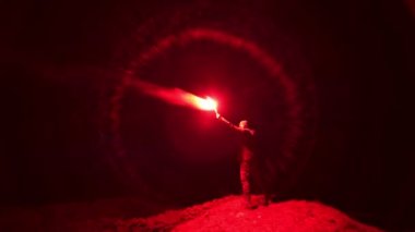 Parlak bir havai fişek sopasıyla dışarıda duran adam.