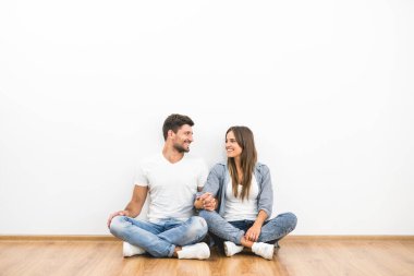 Mutlu adam ve kadın boş duvarın yanında oturuyor.