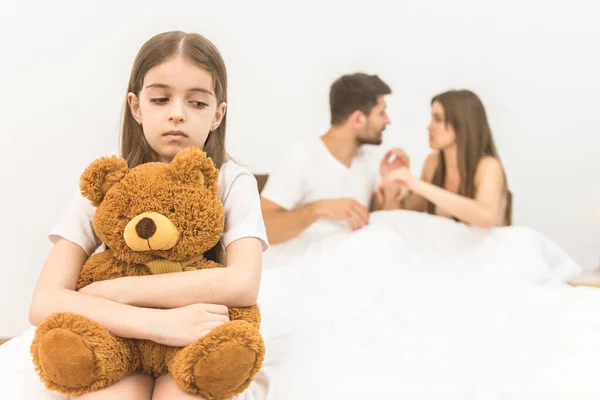 Das Traurige Mädchen Mit Dem Spielzeug Sitzt Neben Den Eltern — Stockfoto