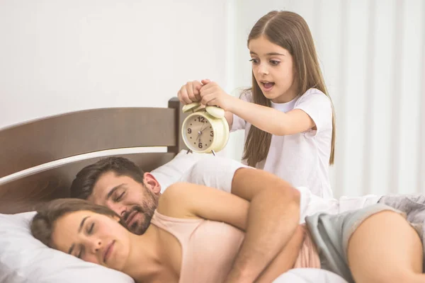 Chica Sostiene Despertador Cerca Los Padres Cama — Foto de Stock