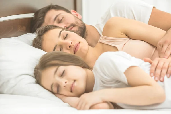 Die Frau Die Neben Der Familie Auf Dem Bequemen Bett — Stockfoto