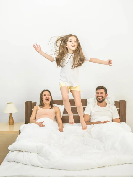Счастливая Девушка Прыгает Кровати Рядом Родителями — стоковое фото