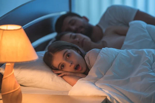 恐怖の少女はベッドの中で眠っている両親の近くに横たわっていた 夜の時間 — ストック写真