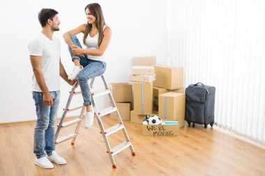 Kutuların arkasındaki merdivenin yanındaki mutlu çift.