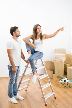 Kutuların arkasındaki merdivenin yanındaki mutlu çift.