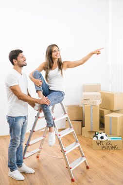 Kutuların arkasındaki merdivenin yanındaki mutlu çift.