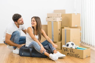 Gülümseyen çift kutuların arkasında oturuyor.