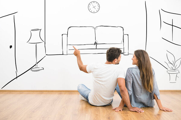 The happy man and woman dream near virtual room on the wall