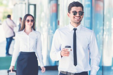 Kadının yanında bir fincan kahve standı olan mutlu iş adamı.