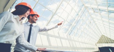 İki mühendis binayı gösteriyor.