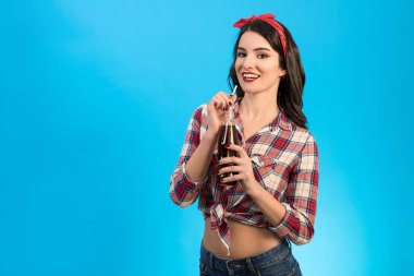 Mavi arka planda içki içen mutlu kadın.