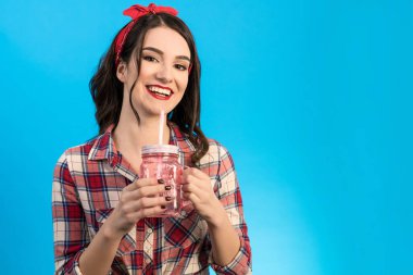 Mavi arka planda içki içen kadın.