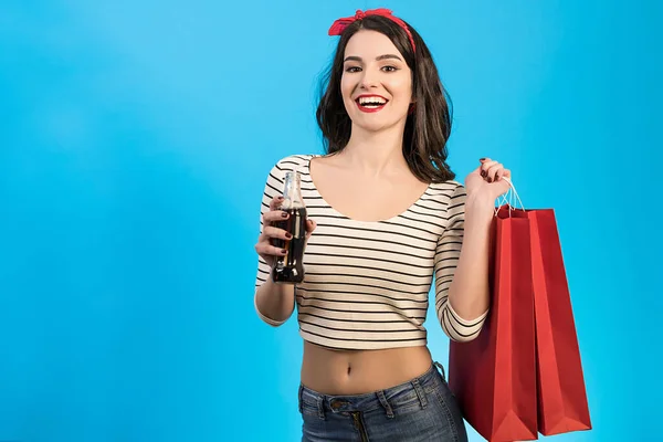 Den Glada Kvinnan Med Påsar Dricka Cola Den Blå Bakgrunden — Stockfoto