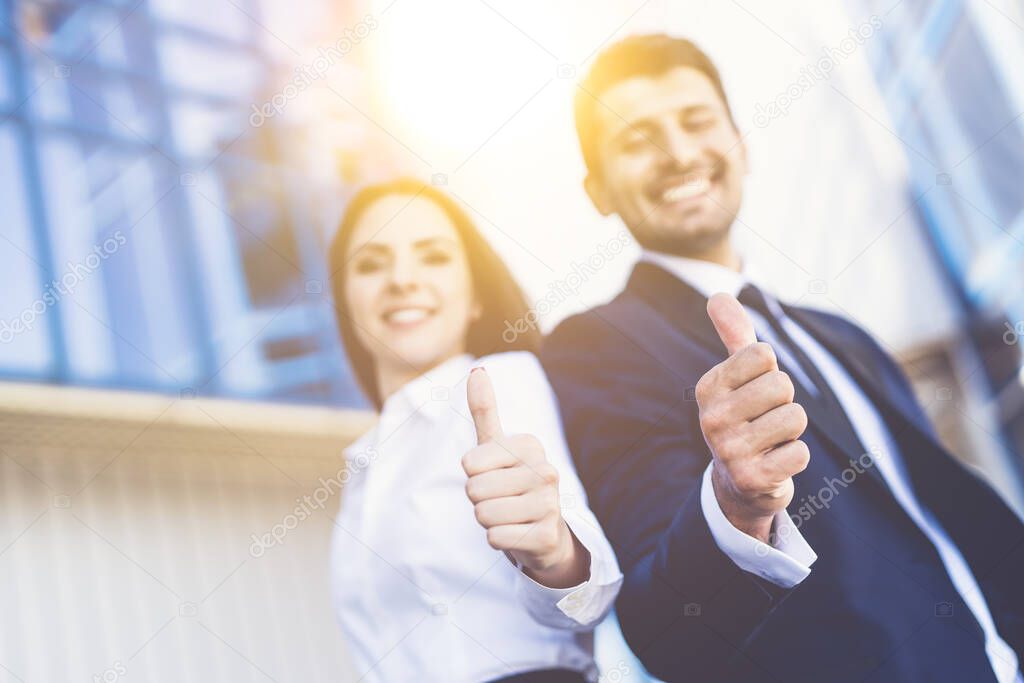 The happy business man and woman thumb up