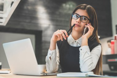 Masaüstünde gözlüklü sevimli iş kadını.