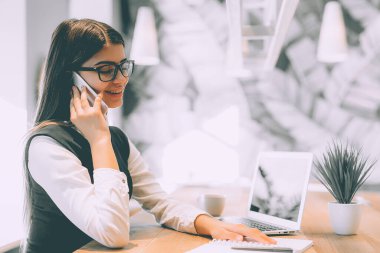 Masadaki güzel kadın telefon eder.