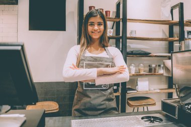 Barın arkasında duran kafe çalışanı.