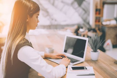 Kafede modern dizüstü bilgisayarla çalışan kadın.