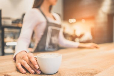 Garson elinde bir fincan kahve tutuyor.