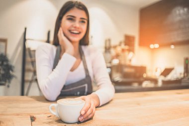 Garson elinde bir fincan kahve tutuyor.