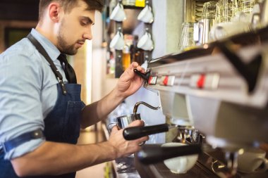 Kahve makinesiyle çalışan adam.