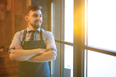 Kafenin içinde duran mutlu adam.