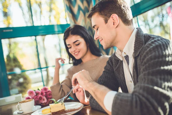 The happy couple eating dessert in the cafe