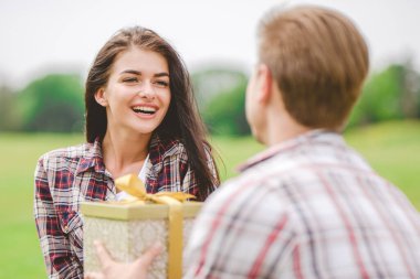 Dışarıdaki bir kadına hediye kutusunu veren adam.