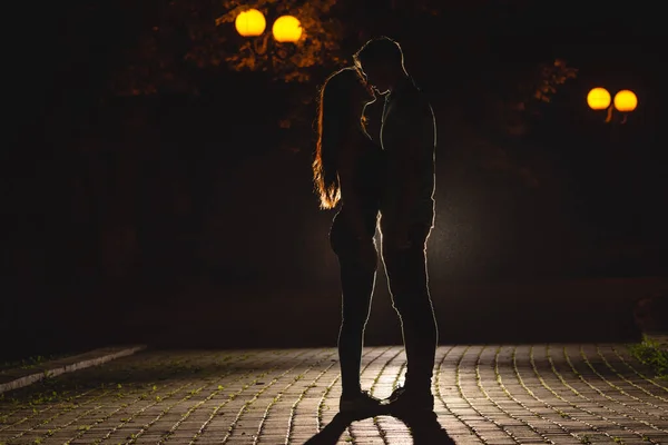 Karanlık sokakta öpüşen çift. Gece vakti.