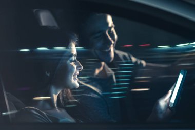 Mutlu çift arabayı ve telefonu kullanıyor. Akşam vakti.