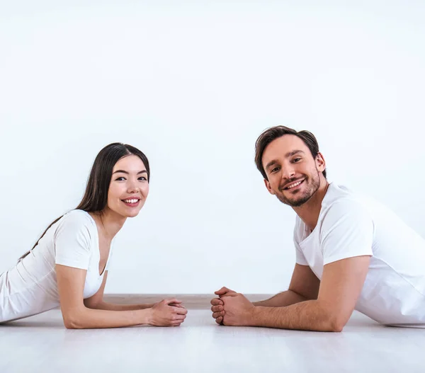 Casal Feliz Deitado Chão Fundo Parede Branca — Fotografia de Stock