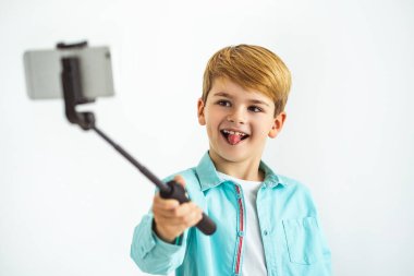 Beyaz arka planda selfie çeken mutlu çocuk.