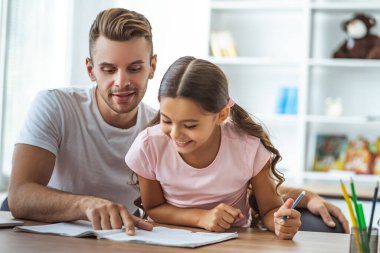 Masada ödev yapan mutlu adam ve kız.