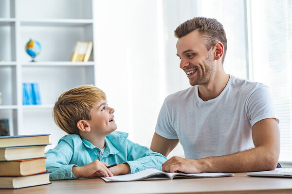 The happy father and a son doing homework at the desk