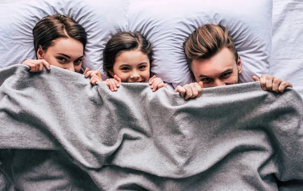幸せな家族が毛布の下に横たわっていた — ストック写真