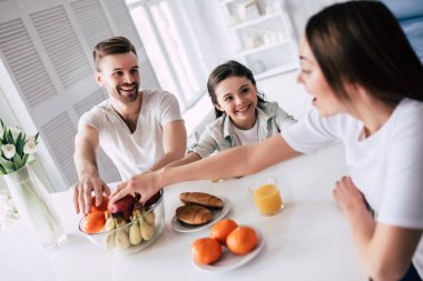 Mutlu aile masada bir elma alıyor.