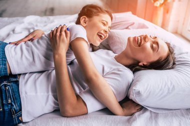 Mutlu kızı ve yatağa gülüyor bir anne