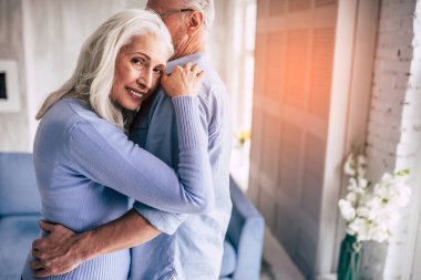 Mutlu yaşlı adam ve sarılan bir kadın.