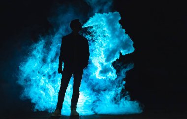 Karanlık arka planda sigara içen adam.