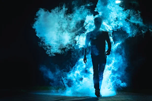 Άντρας Που Περπατά Στον Μπλε Καπνό Στο Σκοτεινό Φόντο — Φωτογραφία Αρχείου