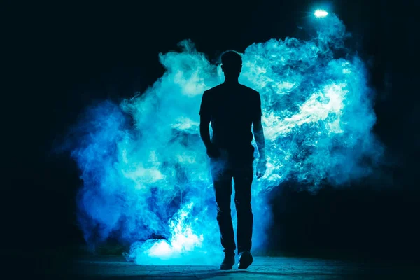 Mannen Som Går Den Blå Røyken Den Mørke Bakgrunnen Kveldstid – stockfoto